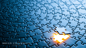 Puzzle wall with a missing piece, representing problem-solving, teamwork, and educational support at Bryan University.