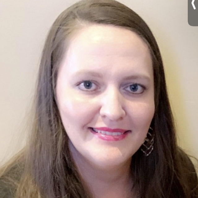 Close-up of a smiling woman with long brown hair, wearing earrings, representing the BU Resource Center's contact staff.