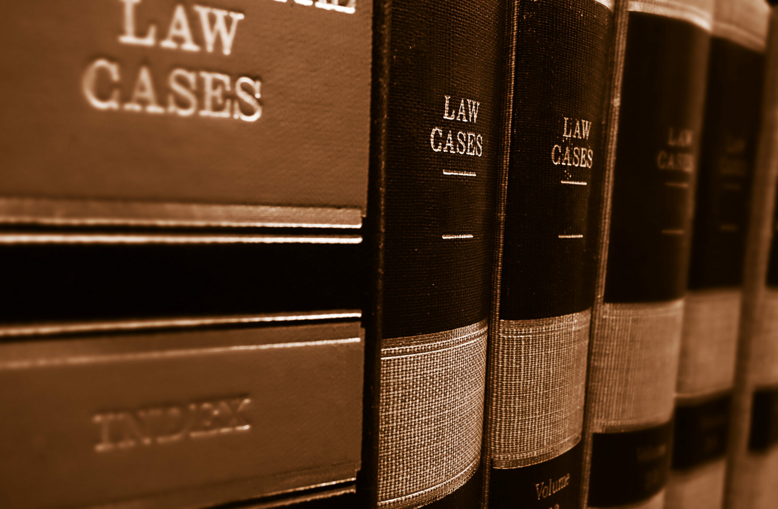 A row of black legal books labeled Law Cases are lined up on a shelf.