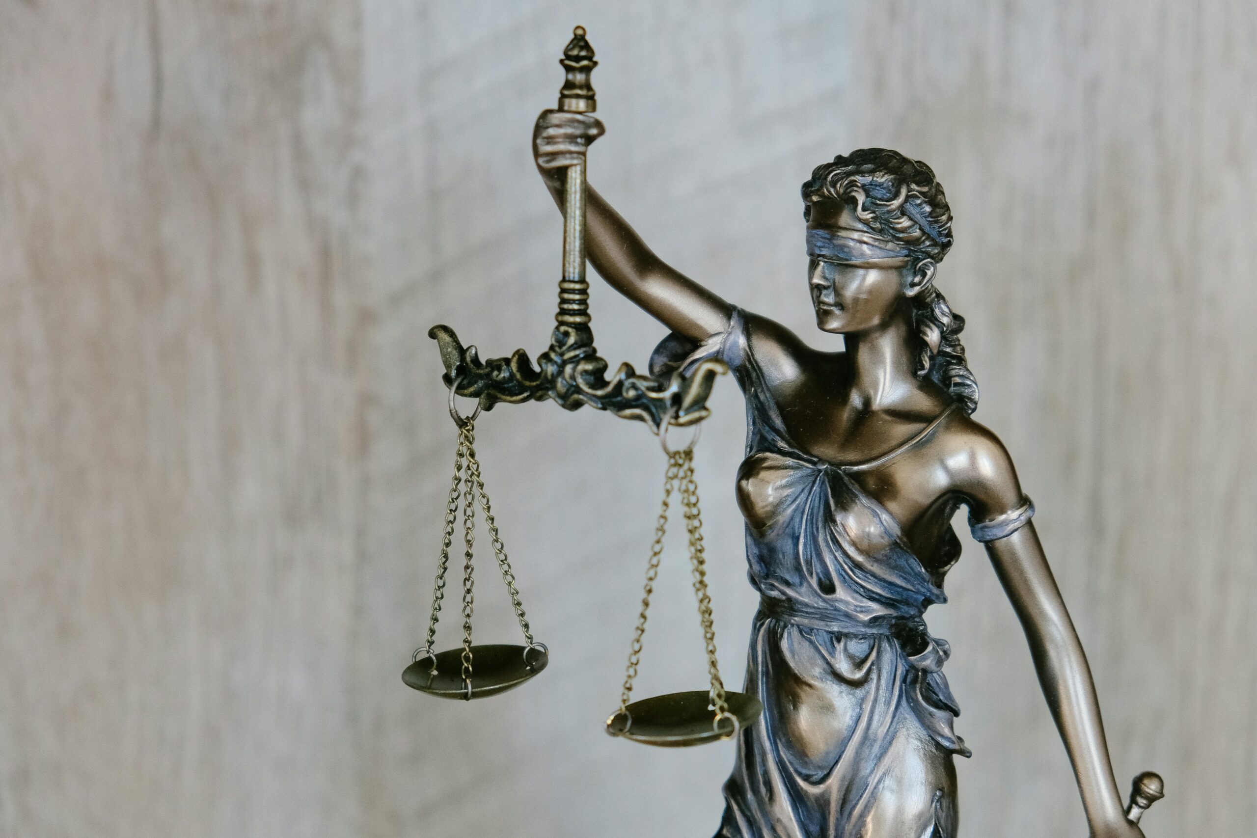 A bronze statue of Lady Justice holding weighing scales.